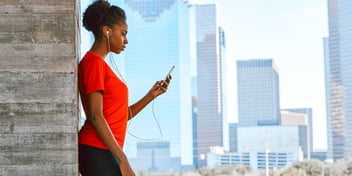 woman with phone by city window