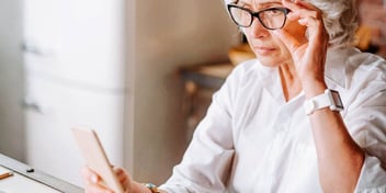 woman holding phone in hand looks concerned