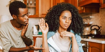 angry woman holds up hand to shoo man away