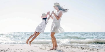 mother and child playing by ocean