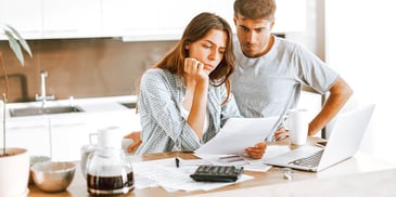 couple reading document together in kitchen