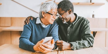 old age male couple sit close together at table