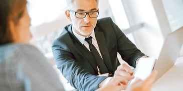 man and woman discussing business assets in an office