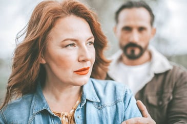 angry woman with red hair turns away from man
