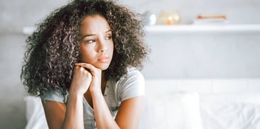 woman looks out window with concern on her face