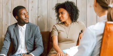 couple on office couch looking at each other