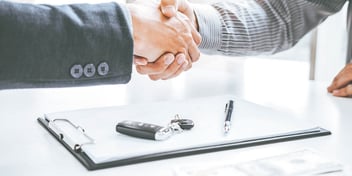hands shaking over a clipboard and keys