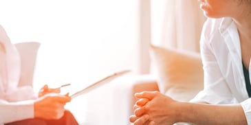 two people talking one holding paper