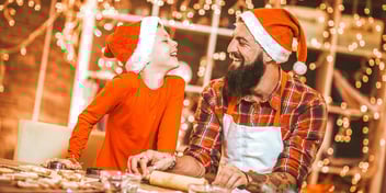 dad and kid smiling in santa hats