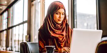 woman looking at laptop in cafe