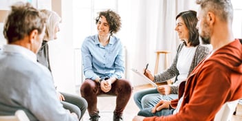family members sitting in chairs in a circle smiling