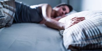 sad person in bed missing their partner who left