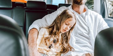 dad hugs sad daughter on bus seat