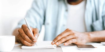 man writing on paper