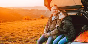 dad and daughter sitting in a field enjoying vacation