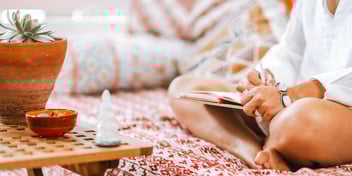 person journaling on couch