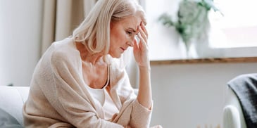 unhappy woman with head in hand