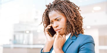 woman outside looking concerned with phone to ear