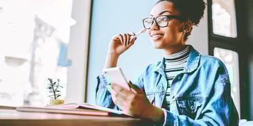 woman smiling about finances while holding phone
