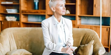 woman on couch with pencil deep in thought 