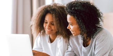 mom and daughter filling out form on computer