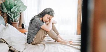 child sitting alone and sad on bed