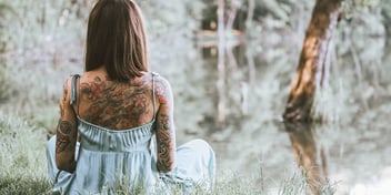 woman meditating by a peaceful river