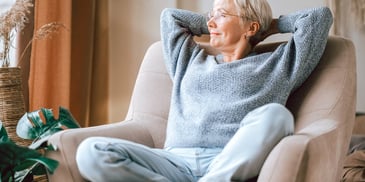 woman stretching happily in sunny chair