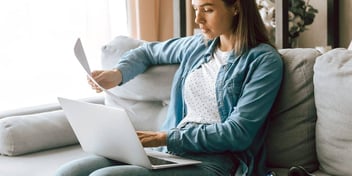 Woman looking at papers and computer