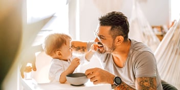 dad feeding baby in morning