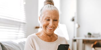 smiling older woman in front of sunny window