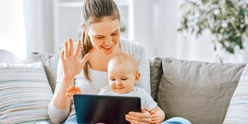 woman waving with infant in lap