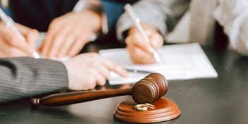judge gavel and hand signing document with pen
