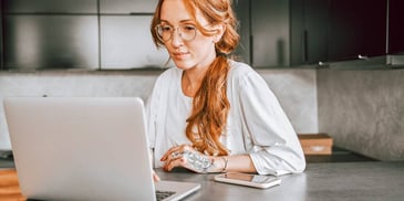 woman reading information on laptop