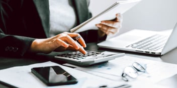 person typing numbers into calculator