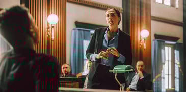 man on the stand in court being questioned by lawyer