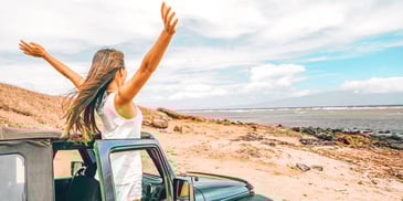 woman stepping outside her car at the beach