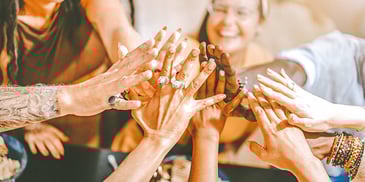 group touching hands together in a circle