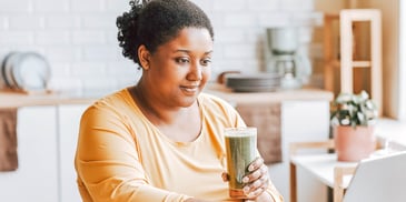 woman drinking from a cup and lost in thought