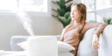 woman with eyes closed taking a stress break on sofa