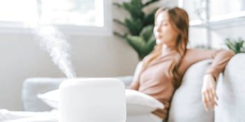 woman with eyes closed taking a stress break on sofa