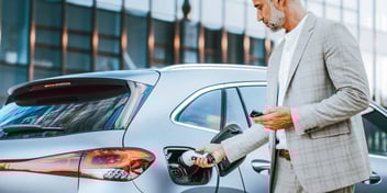 man with white beard pumping gas in car