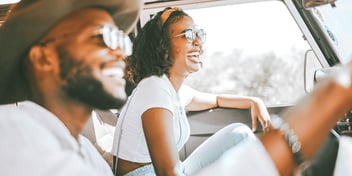 couple driving and smiling in car