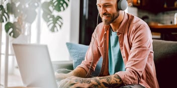 man in sunny window using computer