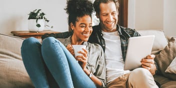 couple smiling while looking at paperwork