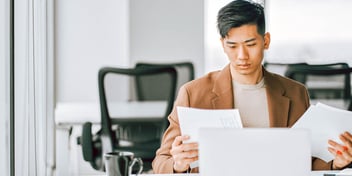 man holding multiple papers in his hands