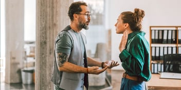 couple having heated discussion in front of window