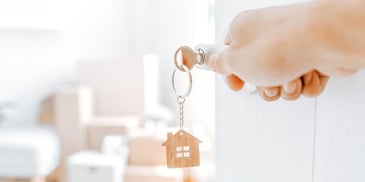 hand turning doorknob with key