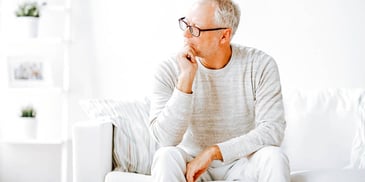 man sitting alone and thinking on a white couch