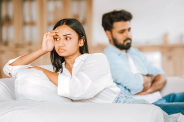annoyed looking woman sitting away from a man